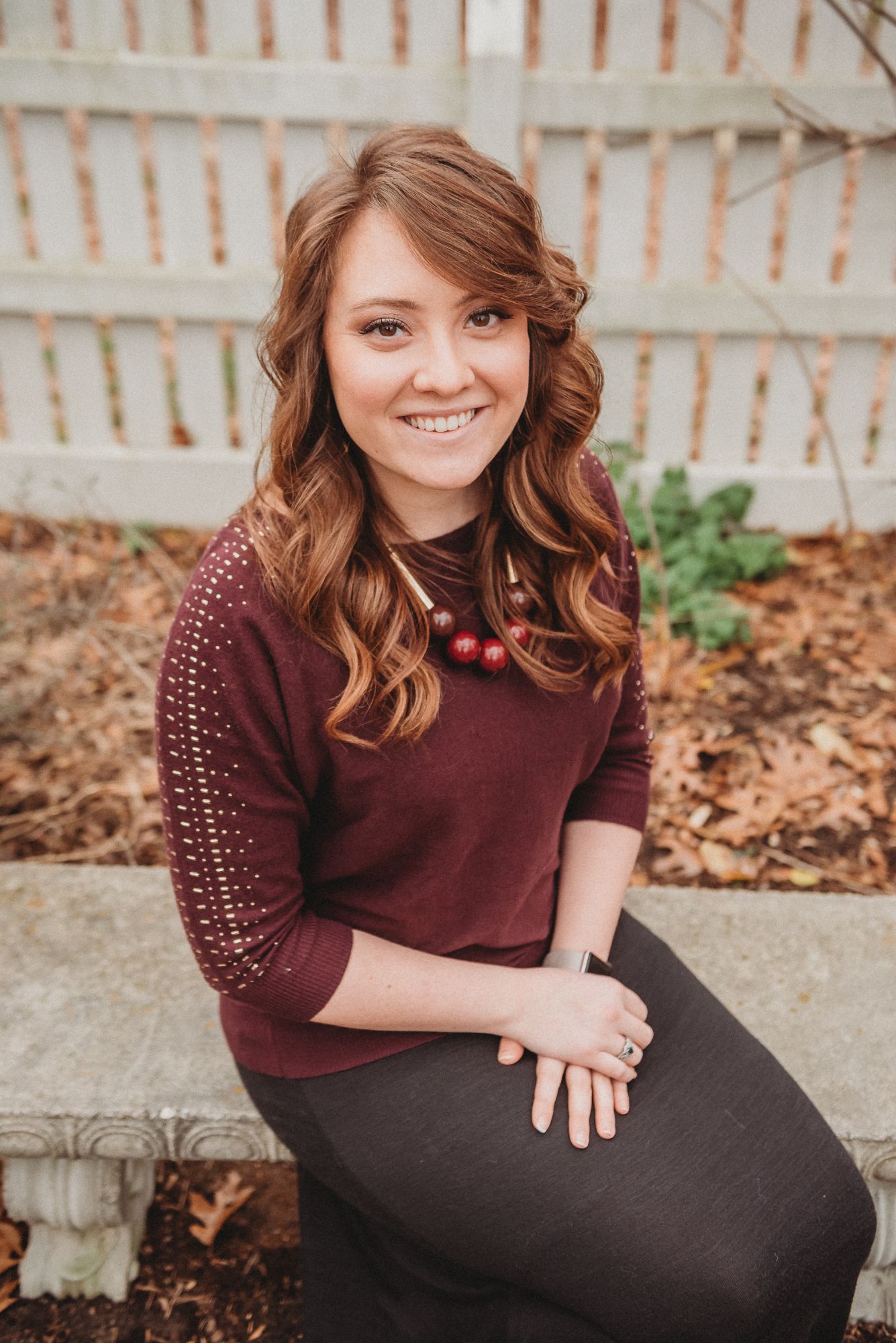 Kendra Hurley, smiling, seated on a stone bench