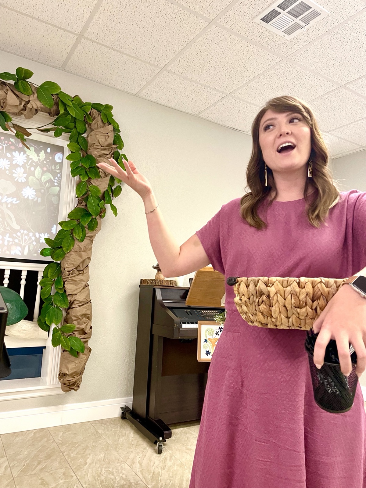 Kendra teaching at the front of a Sunday school room, holding a basket